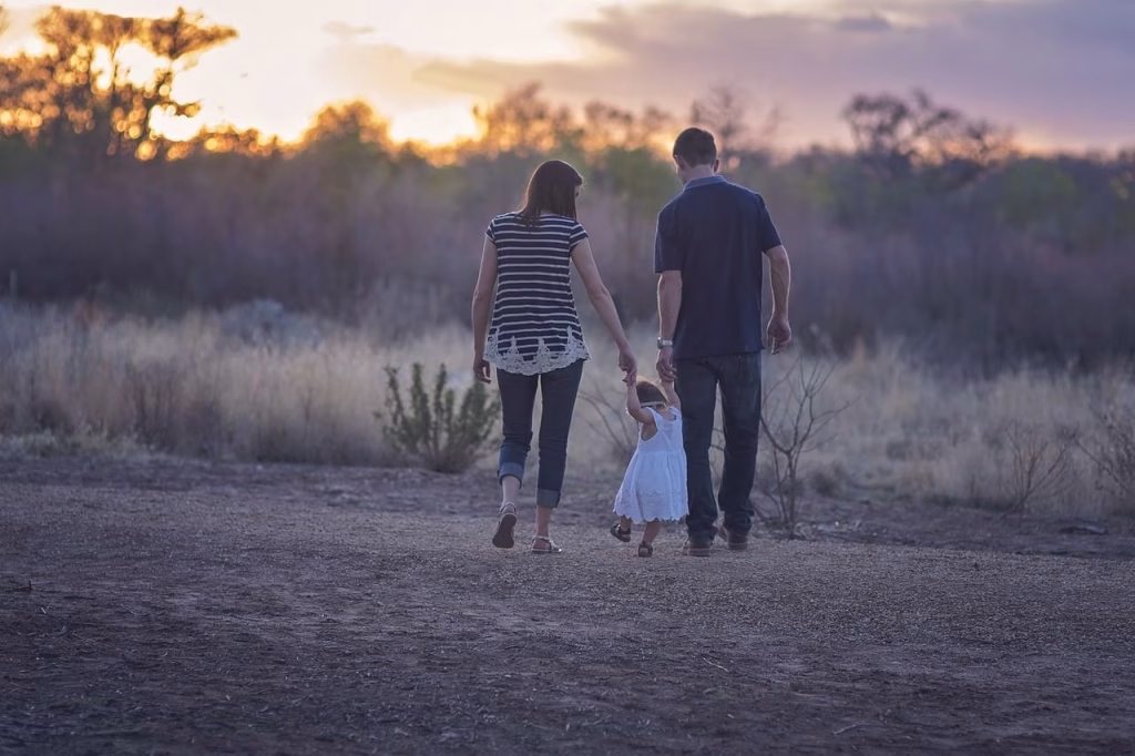 A man and woman guide their child, representing the importance of family support in life's journey.