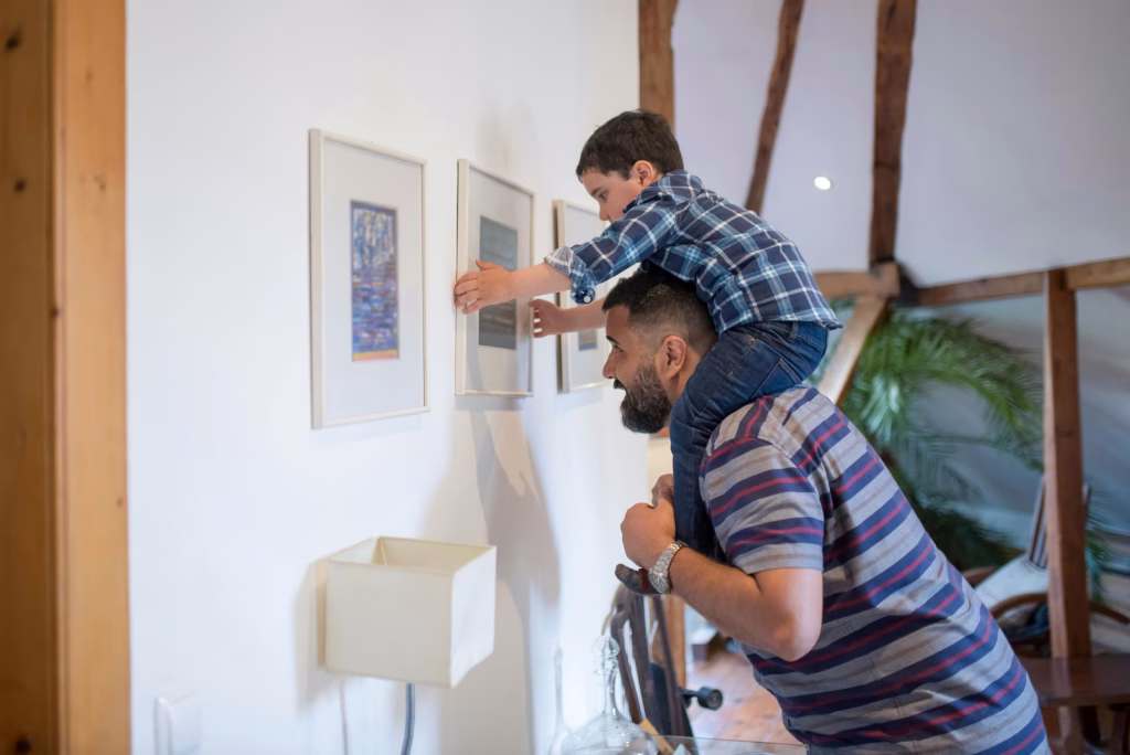A father is hoisting up his son on his shoulders.