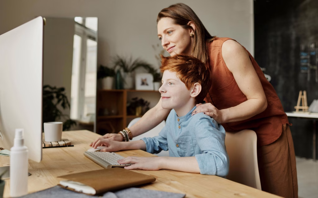 mother teaching her son on the computer.